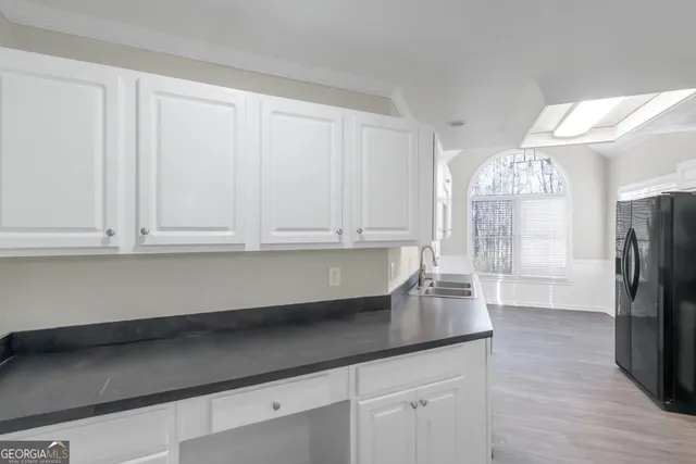 a kitchen with granite countertop a sink stainless steel appliances and cabinets