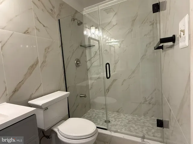 a white toilet sitting next to a shower