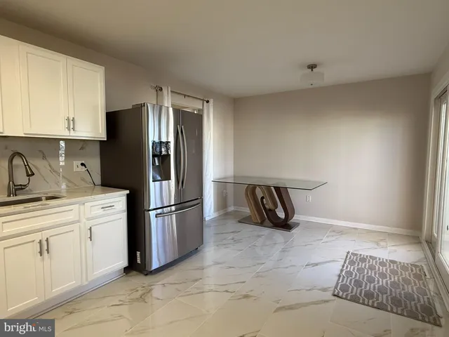 a kitchen with stainless steel appliances granite countertop a refrigerator and a sink