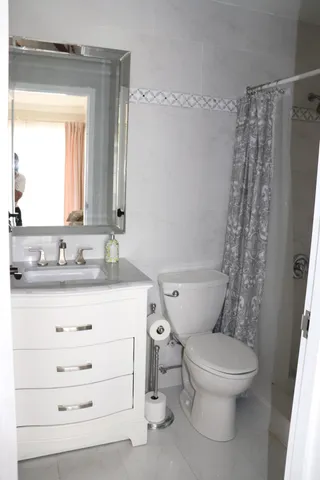 a bathroom with a granite countertop sink toilet and shower