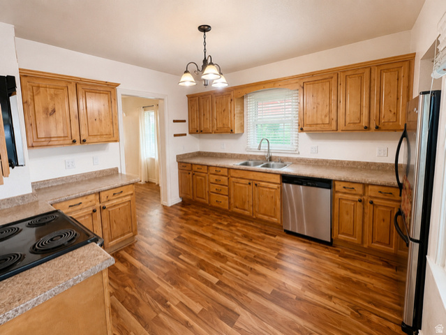 1766 Kenilworth Road Spring Glen, UT 84526 - Photo 4 of 24 Spacious kitchen featuring extensive wood cabinetry, stone-finish countertops, wood-finish flooring, a stainless steel dishwasher, and a double basin sink