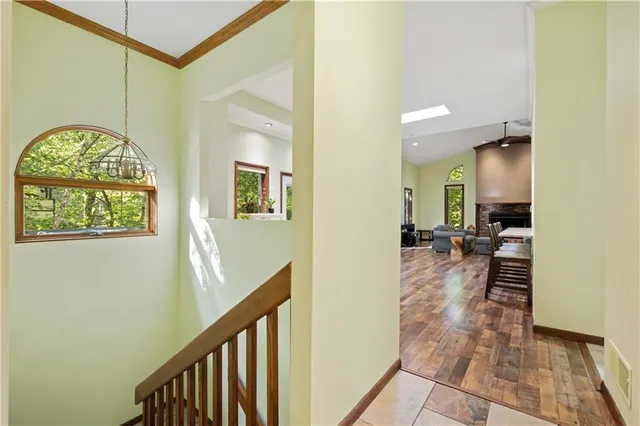 a view of a hallway view with wooden floor and a living room