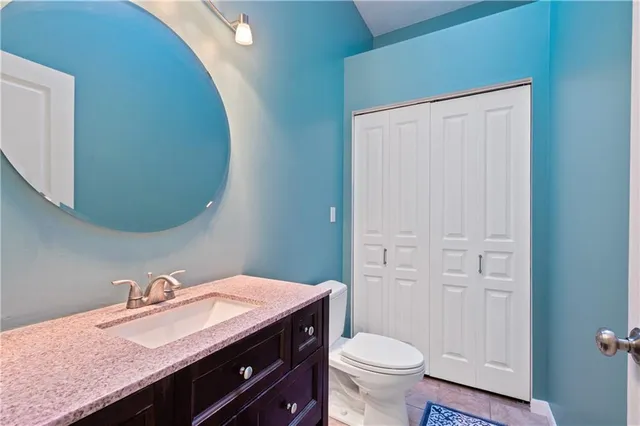 a bathroom with a granite countertop sink a toilet and a mirror