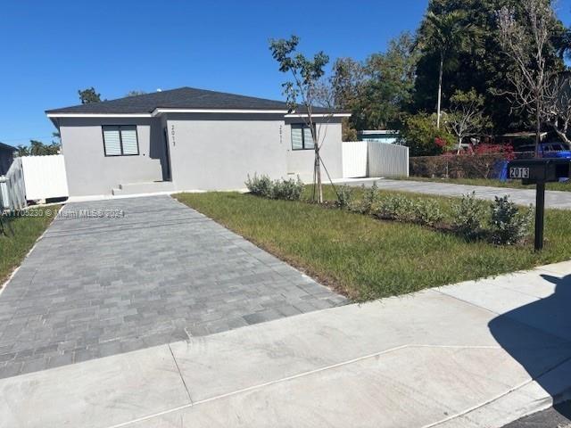 2011 Northwest 26th Street, Unit 2011 Miami, FL 33142 - Photo 2 of 7 a front view of a house with a yard and garage