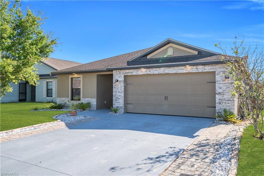 175 Shadowview Court Lehigh Acres, FL 33974 - Photo 5 of 39 a view of a house with a yard and garage