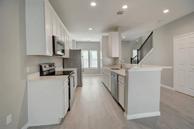a view of kitchen with stainless steel appliances refrigerator oven and cabinets
