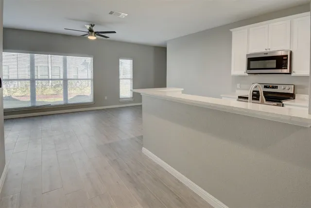 a kitchen with a sink cabinets and wooden floor