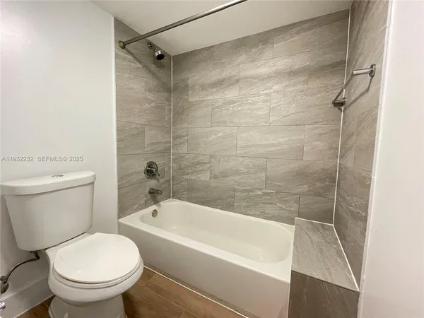 a white bath tub sitting next to a white toilet and a shower