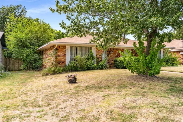 a view of a house with a yard and potted plants