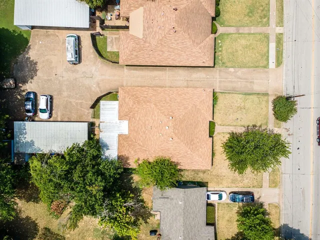 an aerial view of residential houses with outdoor space and parking