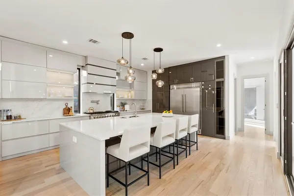 a kitchen with kitchen island a stove a table and chairs in it