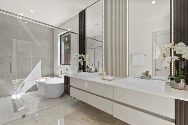a bathroom with a double vanity sink mirror and bathtub