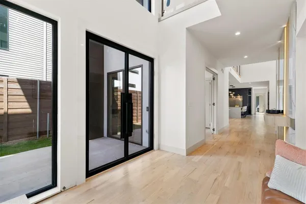 a view of a hallway with wooden floor and a living room