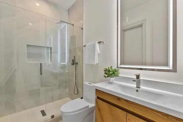 a bathroom with a sink a toilet and a mirror