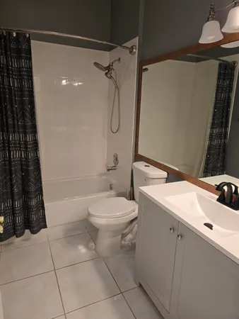 a bathroom with a granite countertop sink a toilet and shower