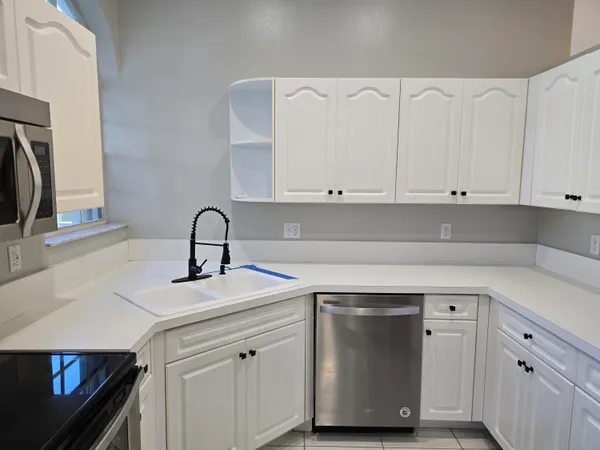a kitchen with white cabinets and a sink