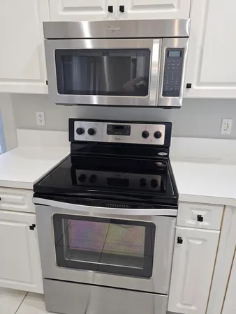 a stove top oven sitting inside of a kitchen with stainless steel appliances