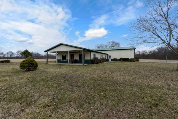a front view of house with yard and trees around