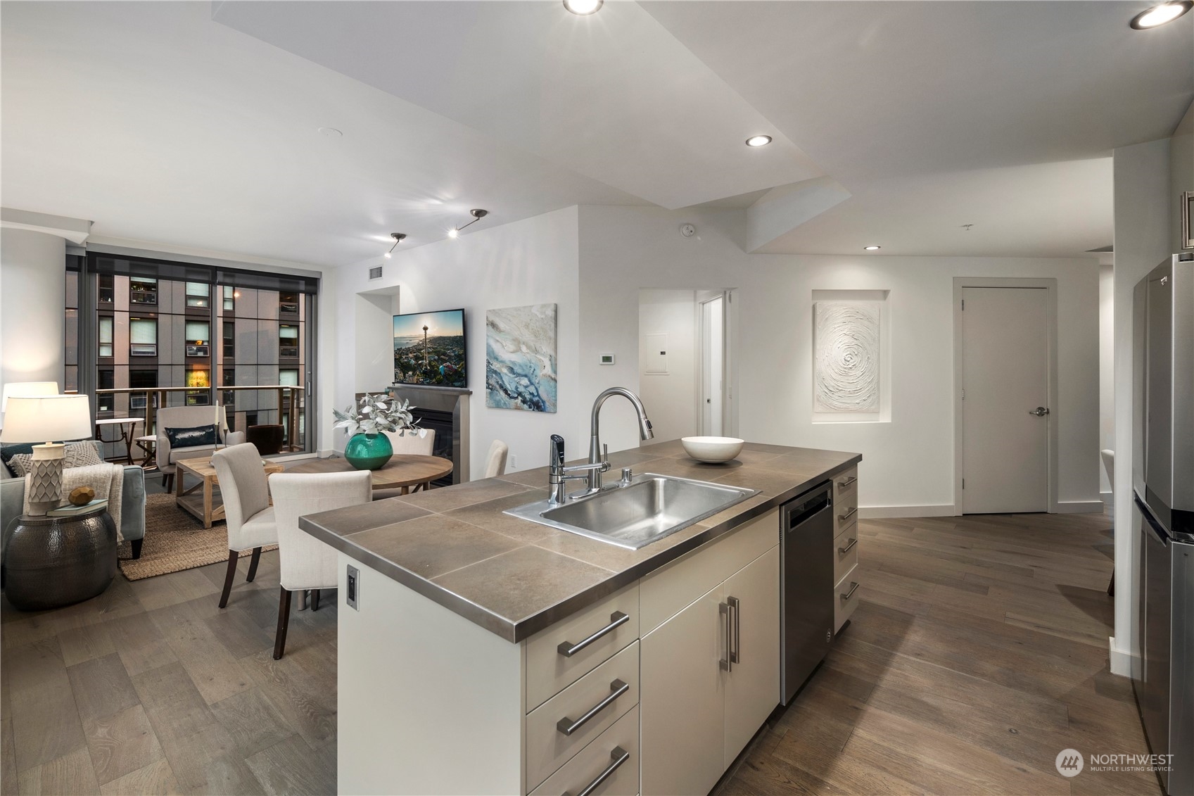 910 Lenora Street, Unit S1003 Seattle, WA 98121 - Photo 11 of 28 a kitchen with granite countertop a sink and white cabinets