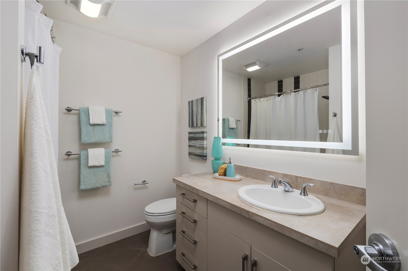 910 Lenora Street, Unit S1003 Seattle, WA 98121 - Photo 14 of 28 a bathroom with a toilet sink and mirror
