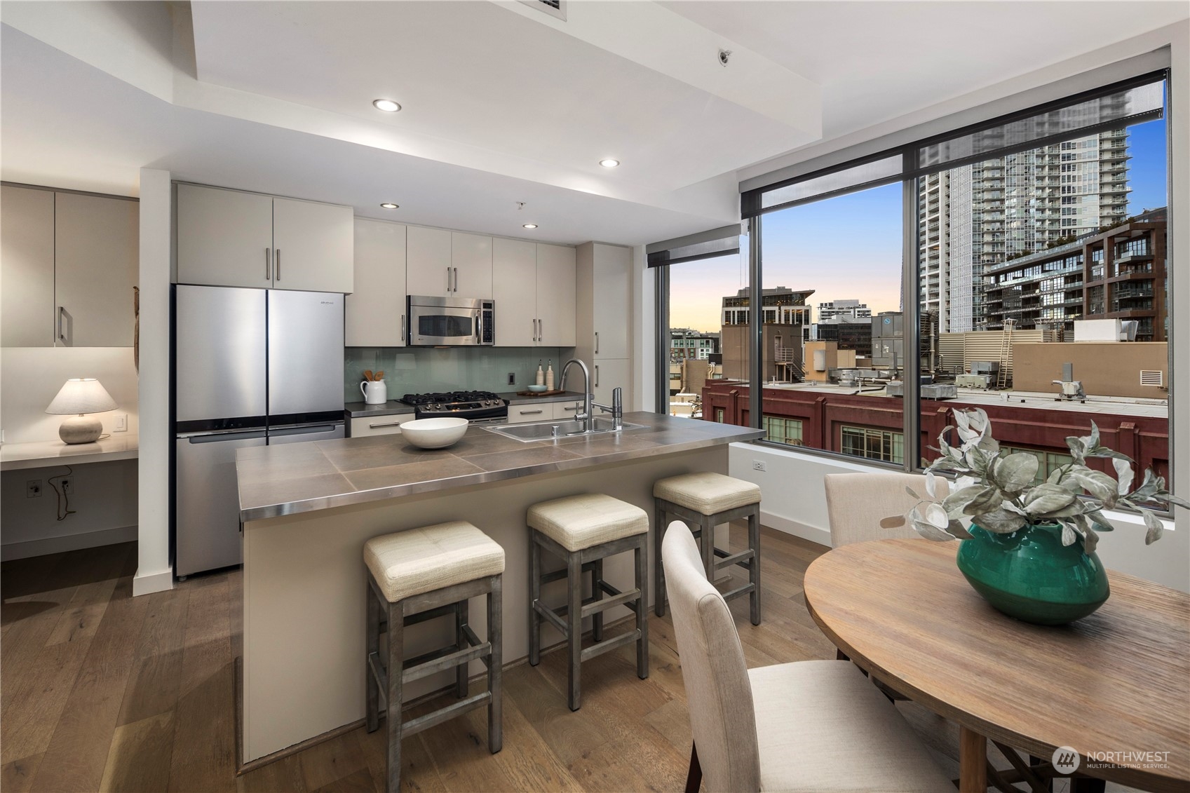 910 Lenora Street, Unit S1003 Seattle, WA 98121 - Photo 8 of 28 a kitchen with sink a refrigerator and chairs