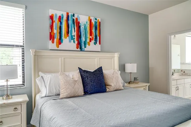 a bedroom with a bed and a painting on the wall