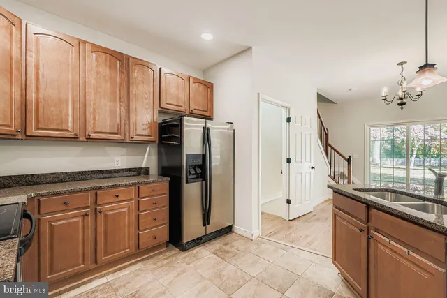 a kitchen with stainless steel appliances granite countertop a refrigerator and a sink