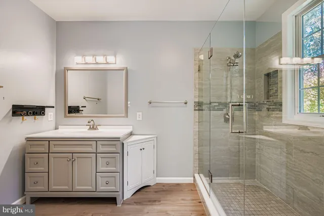 a bathroom with a shower sink and mirror