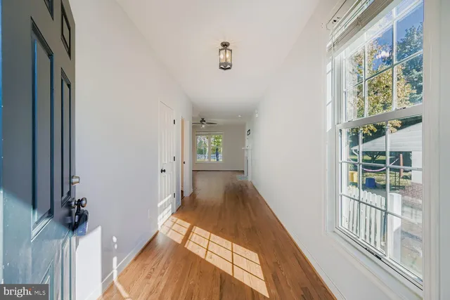 a view of a hallway with wooden floor and staircase