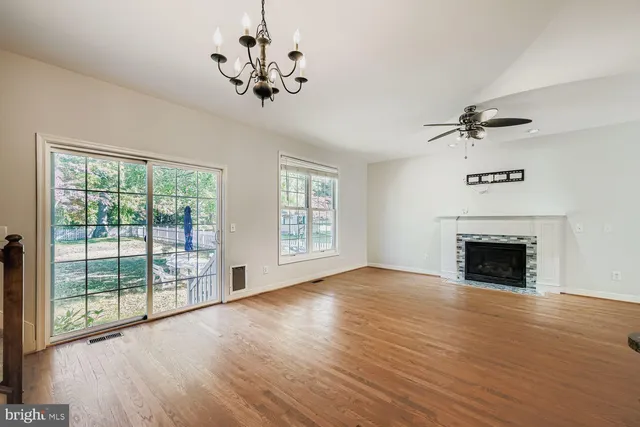 a view of an empty room with a fireplace and a window