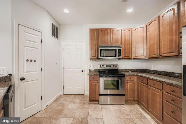 a kitchen with stainless steel appliances granite countertop a stove top oven a sink and dishwasher