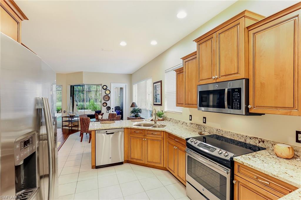2885 Lone Pine Lane Naples, FL 34119 - Photo 11 of 29 a kitchen with stainless steel appliances kitchen island granite countertop a sink stove and cabinets