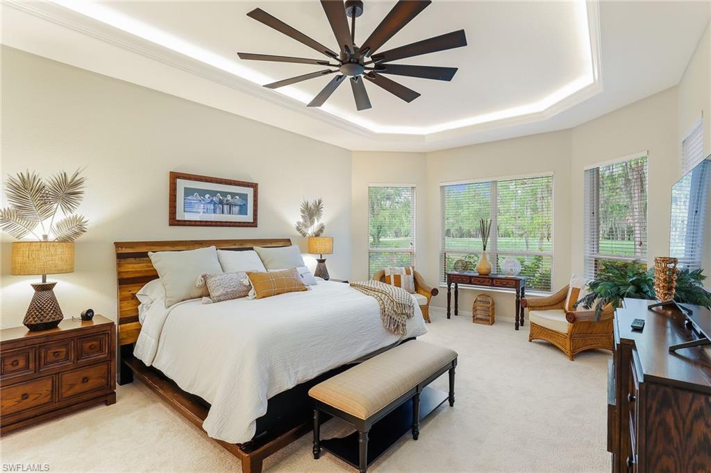 2885 Lone Pine Lane Naples, FL 34119 - Photo 13 of 29 a bedroom with a bed a couch and a large window