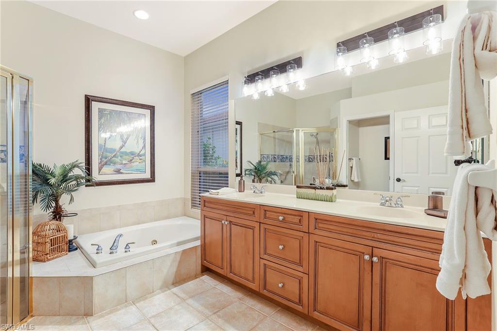 2885 Lone Pine Lane Naples, FL 34119 - Photo 14 of 29 a spacious bathroom with a tub sink and mirror