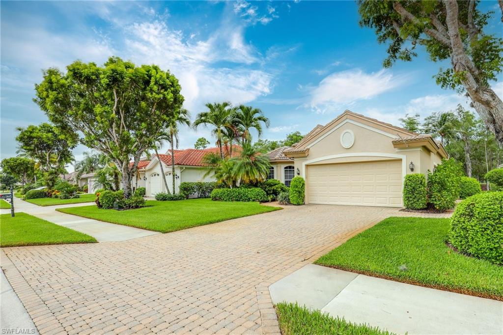 2885 Lone Pine Lane Naples, FL 34119 - Photo 25 of 29 a front view of a house with a yard and garage