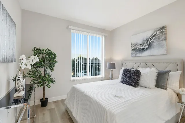 a bedroom with a large bed and a potted plant
