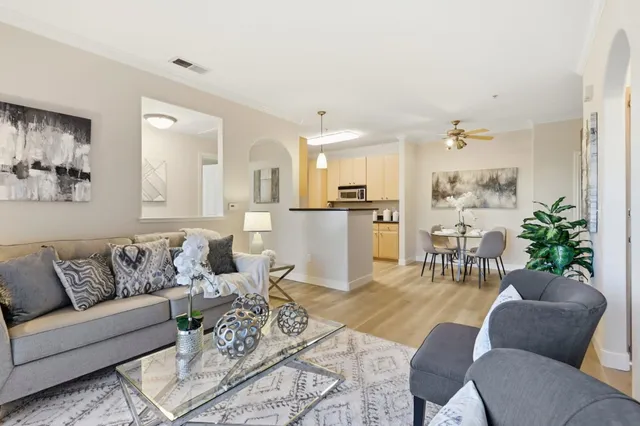 a living room with furniture and a dining table with kitchen view