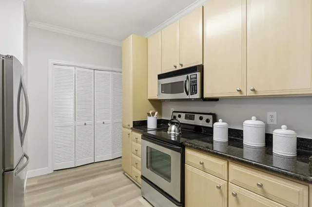 a kitchen with stainless steel appliances granite countertop white cabinets a refrigerator and a stove