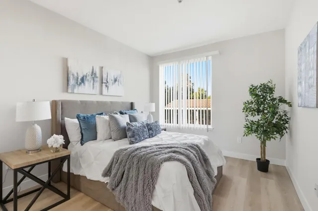 a bedroom with a bed and a potted plant