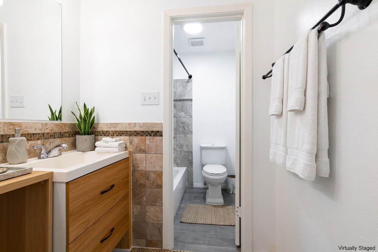 706 Ramble Lane, Unit B Austin, TX 78745 - Photo 11 of 12 a bathroom with a sink a toilet and shower