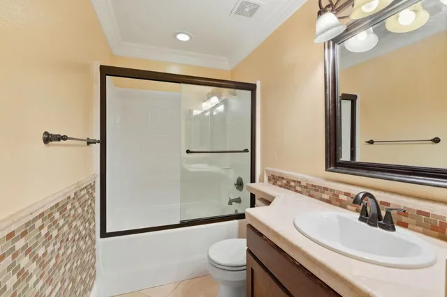 a bathroom with a tub sink shower and mirror