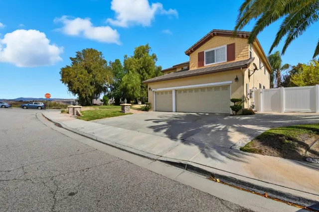 a view of an empty room with wooden floor and stairs