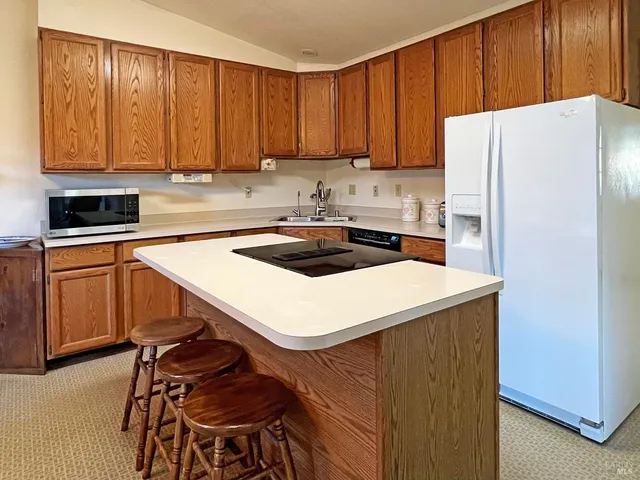 a kitchen with a stove a refrigerator and wooden cabinets