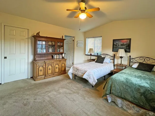 a spacious bedroom with two bed and a chandelier