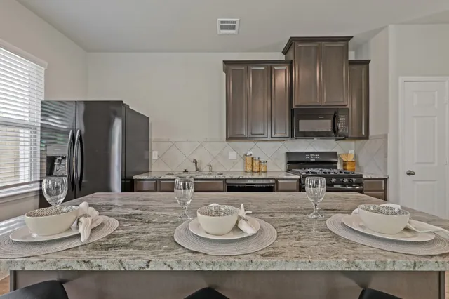 a kitchen with granite countertop a sink and a stove top oven