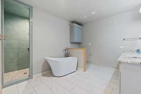 a bathroom with a tub sink and mirror