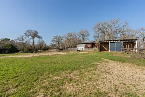 a view of a house with backyard and trees