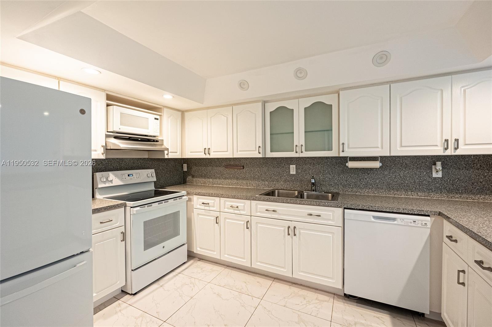 6534 Southwest 114th Place, Unit G75 Miami, FL 33173 - Photo 17 of 52 a kitchen with white cabinets stainless steel appliances and sink