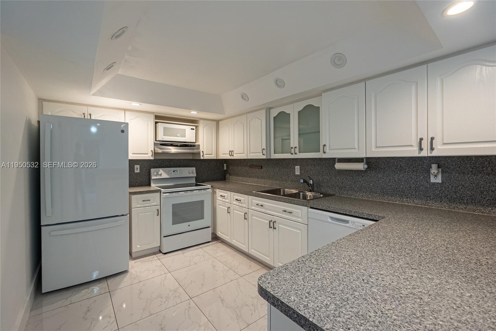 6534 Southwest 114th Place, Unit G75 Miami, FL 33173 - Photo 19 of 52 a kitchen with stainless steel appliances granite countertop a refrigerator sink and cabinets