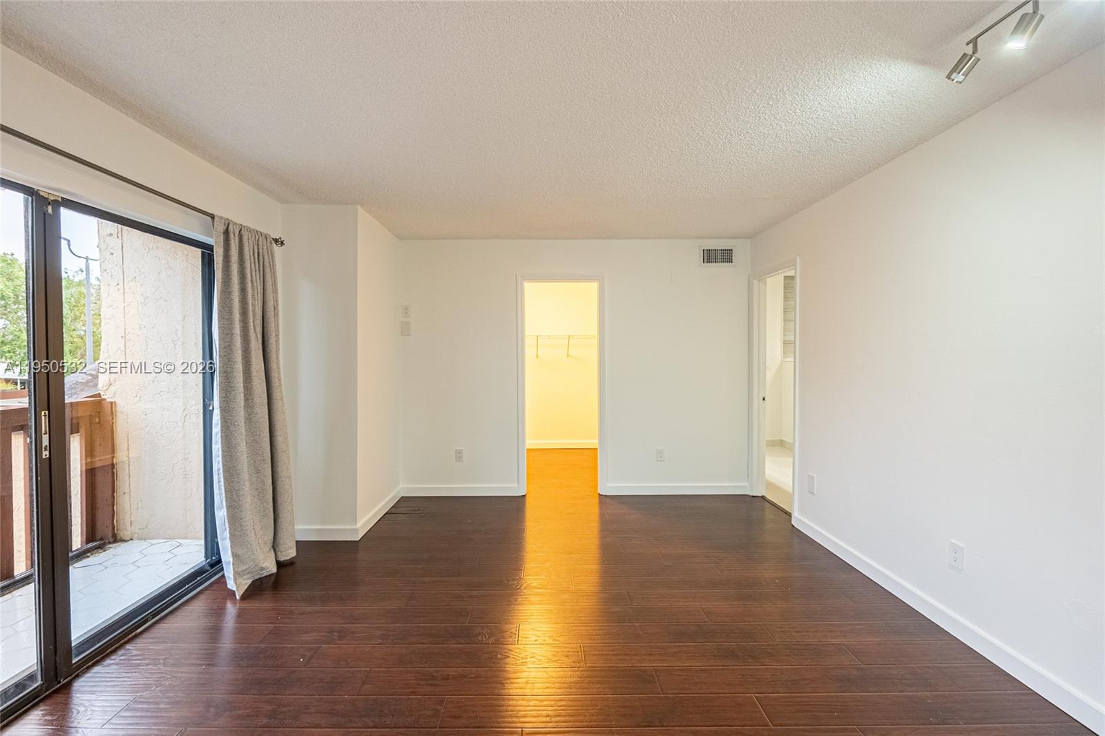 6534 Southwest 114th Place, Unit G75 Miami, FL 33173 - Photo 23 of 52 a view of an empty room with wooden floor and a window